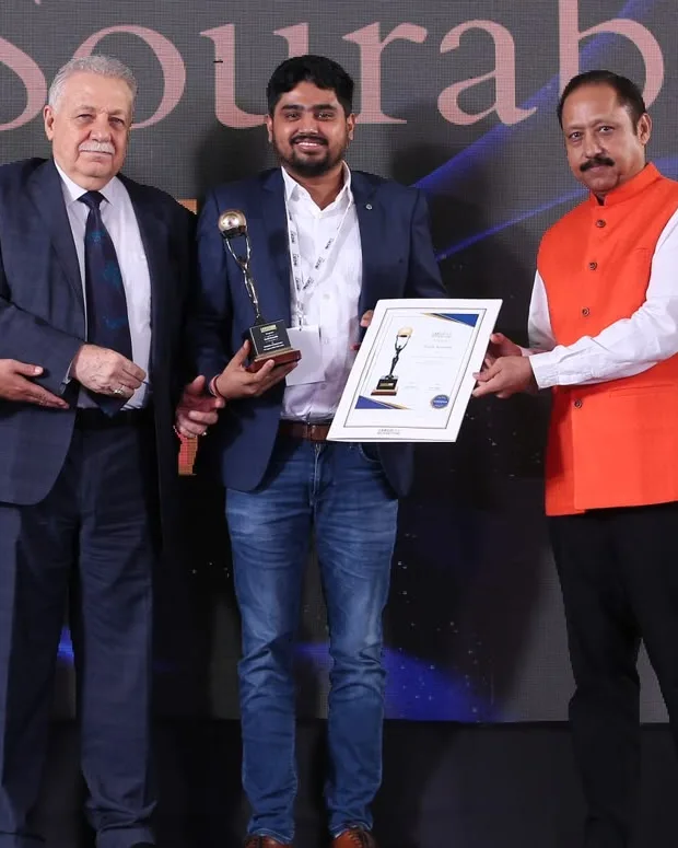 Sonik Sourabh on stage holding an award trophy